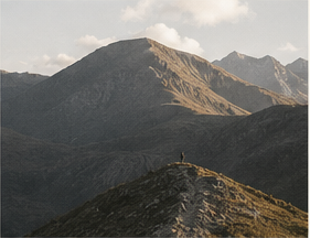 A mountain ridge in warm light with distant peaks
